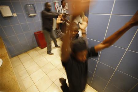 Armed police search customers inside a bathroom while combing through a shopping centre for gunmen in Nairobi